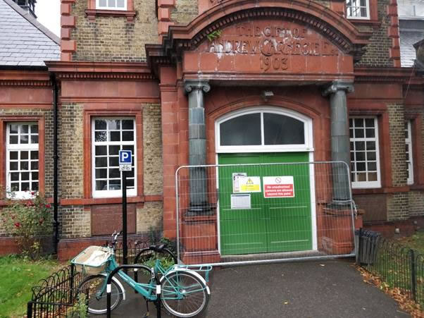 A bicycle parked in front of a brick building Description automatically generated