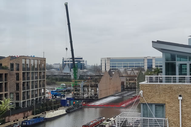 A crane dismantling warehouses on Commerce Road