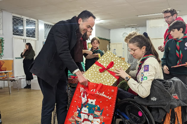 James Murray helps a scout gift wrap a present for a young care leaver