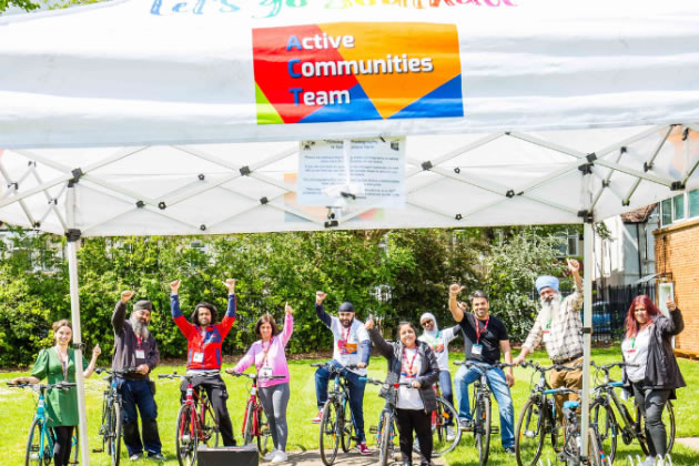 Southall residents celebrating getting their free bikes